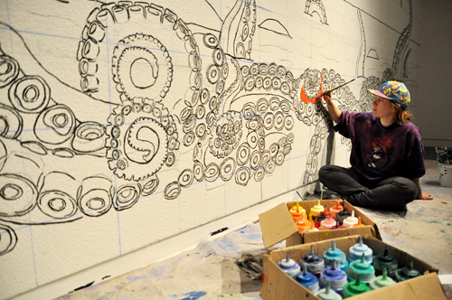 Artist at work: Robin Corbo colors in a new piece in the Autzen Gallery.