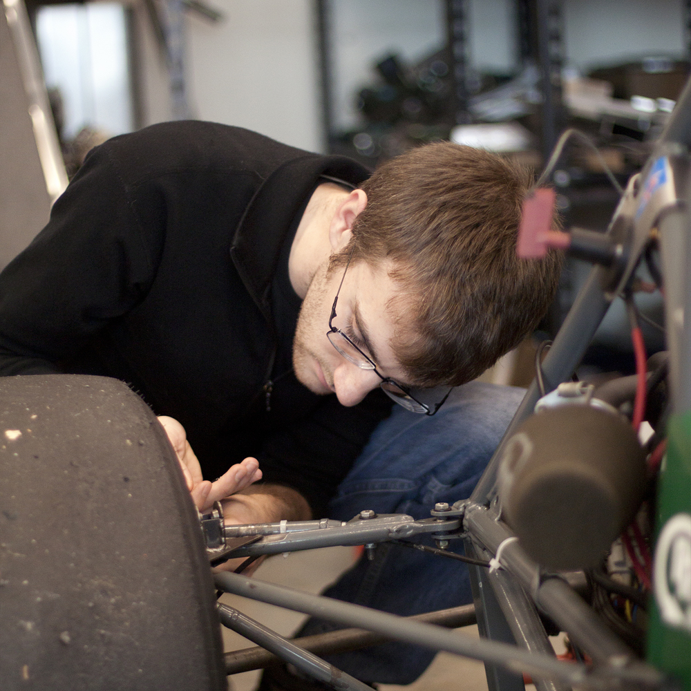 Troy Brown, technical director at Viking Motorsports, works on the group's gas-powered car in PSU's engineering building. Photo by Miles Sanguinetti